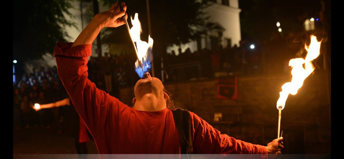 Feuerschlucken in Feuershow bei Wald leuchtet